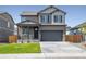 Two-story house with gray siding, stone accents, and a two-car garage at 9876 Ceylon Ct, Commerce City, CO 80022