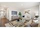 Spacious living room with hardwood floors, neutral decor, and a large TV at 9876 Ceylon Ct, Commerce City, CO 80022