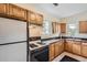 Functional kitchen featuring wooden cabinets, black countertops, and modern appliances at 2831 W Irvington Pl, Denver, CO 80219