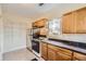 Kitchen featuring wooden cabinets, black countertops, and modern appliances at 2831 W Irvington Pl, Denver, CO 80219
