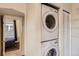 Convenient laundry area with stacked washer and dryer, plus built-in shelving for organization at 2831 W Irvington Pl, Denver, CO 80219