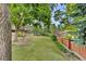 Backyard featuring tiered landscaping, artificial turf, retaining wall, and wooden fence at 4678 Springmeadow Ln, Castle Rock, CO 80109