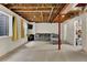 Partially finished basement with exposed ceiling, gray sofa, tv, and storage area at 4678 Springmeadow Ln, Castle Rock, CO 80109