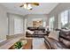 Cozy living room featuring leather sofas, a ceiling fan, and large windows offering ample natural light at 4678 Springmeadow Ln, Castle Rock, CO 80109