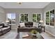 Comfortable living room featuring leather sofas, large windows with backyard views, and wood flooring at 4678 Springmeadow Ln, Castle Rock, CO 80109
