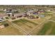 Aerial view of sprawling fenced in property featuring a pergola, sports court, and meticulously maintained landscaping at 12590 Valentia St, Thornton, CO 80602