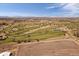 Aerial view of a pristine golf course surrounded by scenic landscapes and clear blue skies at 12590 Valentia St, Thornton, CO 80602