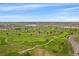 Aerial view of a lush golf course with manicured greens, winding paths, and tranquil water features at 12590 Valentia St, Thornton, CO 80602