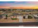 Expansive aerial view of a ranch home with manicured landscaping, outbuildings, and fenced yard at sunset at 12590 Valentia St, Thornton, CO 80602