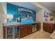 Basement wet bar featuring blue tiled backsplash, display lighting, wine cooler, granite countertops, and stainless steel appliances at 12590 Valentia St, Thornton, CO 80602