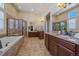 Spacious bathroom featuring double vanities, granite countertops, a soaking tub, and a glass enclosed shower at 12590 Valentia St, Thornton, CO 80602