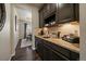 Functional coffee bar featuring rich cabinetry, granite countertops, and backsplash, perfect for beverage preparation at 12590 Valentia St, Thornton, CO 80602