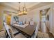 Dining space featuring tray ceiling, chandelier, and decorative buffet at 12590 Valentia St, Thornton, CO 80602