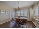 Beautiful dining room featuring an elegant light fixture, many windows, and dark wood flooring at 12590 Valentia St, Thornton, CO 80602