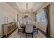 Elegant dining room with modern chandelier, neutral walls, and hardwood flooring at 12590 Valentia St, Thornton, CO 80602