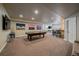 Finished basement game room with pool table, bar with seating, and multiple city skyline paintings at 12590 Valentia St, Thornton, CO 80602