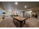 Spacious game room with pool table, wet bar with barstool seating, and staircase access to the upper level at 12590 Valentia St, Thornton, CO 80602