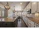 Bright kitchen featuring a spacious island, stainless steel appliances, and seamless connection to the breakfast area at 12590 Valentia St, Thornton, CO 80602