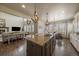 Bright, open kitchen and living area featuring a granite island, hardwood floors and modern lighting at 12590 Valentia St, Thornton, CO 80602