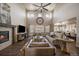 Bright living room featuring a high ceiling, fireplace, open floor plan, and neutral-toned furniture at 12590 Valentia St, Thornton, CO 80602