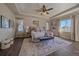 A well-lit main bedroom suite with a ceiling fan, large rug, and cushioned bench at the foot of the bed at 12590 Valentia St, Thornton, CO 80602