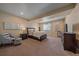 Spacious main bedroom with a large bed, soft neutral decor, bedside tables, and a window seat at 12590 Valentia St, Thornton, CO 80602
