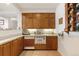 A basement bar area with wooden cabinets, tiled flooring, and granite countertops at 60 Glenalla Pl, Castle Rock, CO 80108