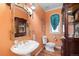 Charming bathroom featuring a pedestal sink, unique mirror and an arched window at 60 Glenalla Pl, Castle Rock, CO 80108