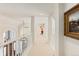 Bright upper hallway with white railings, arched windows, and an art piece at 60 Glenalla Pl, Castle Rock, CO 80108