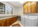 Inviting laundry room with wood cabinets, granite countertops, washer, and dryer at 60 Glenalla Pl, Castle Rock, CO 80108