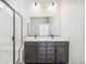 Modern bathroom with a double sink vanity, black hardware, and a walk-in shower at 9265 Cathay Ct, Commerce City, CO 80022