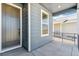 Covered front porch featuring modern gray siding and a stylish front door at 9265 Cathay Ct, Commerce City, CO 80022
