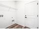Bright laundry room featuring a laminate floor, shelving, and connections for a washer and dryer at 9265 Cathay Ct, Commerce City, CO 80022