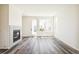 Bright living room with light gray wood flooring, fireplace, and plenty of natural light at 9265 Cathay Ct, Commerce City, CO 80022