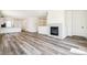 Open-concept living space with light gray wood floors and modern fireplace at 9265 Cathay Ct, Commerce City, CO 80022