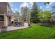 Spacious backyard featuring manicured lawn, trampoline, custom patio with room for dining and grilling at 5766 S Fulton Way, Greenwood Village, CO 80111