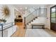 Bright entryway featuring hardwood floors, a staircase with iron railings, and a view into the living room at 5766 S Fulton Way, Greenwood Village, CO 80111