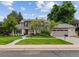 Charming home with a manicured lawn, mature trees, and a curved walkway leading to the front door at 5766 S Fulton Way, Greenwood Village, CO 80111