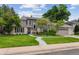 Charming home with a manicured lawn, mature trees, and a curved walkway leading to the front door at 5766 S Fulton Way, Greenwood Village, CO 80111