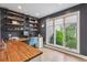 Bright office space with wood desk, built-in shelving, and a large window offering a pleasant view at 5766 S Fulton Way, Greenwood Village, CO 80111