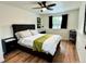 Comfortable bedroom featuring wood floors, ceiling fan, and a large window for natural light at 10785 W 63Rd Pl # 108, Arvada, CO 80004