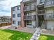 Exterior shot of a condominium building with well maintained grounds and open stairways to upper units at 10785 W 63Rd Pl # 108, Arvada, CO 80004