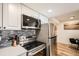 Modern kitchen featuring stainless steel appliances, white cabinets, and a stylish backsplash design at 10785 W 63Rd Pl # 108, Arvada, CO 80004