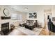 Cozy living room featuring a fireplace, large windows, comfortable seating, and stylish decor at 10785 W 63Rd Pl # 108, Arvada, CO 80004