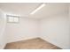 Clean basement with laminate flooring and a small window offers potential for various uses at 814 S High St, Denver, CO 80209