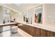 Bright bathroom featuring a vanity with dual sinks, sleek wood cabinets, and a large window bringing in natural light at 814 S High St, Denver, CO 80209