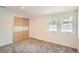 Comfortable bedroom featuring plush carpeting, a closet with sliding doors, and multiple windows for ample natural light at 814 S High St, Denver, CO 80209