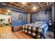Bedroom with an exposed ceiling, and a comfortable bed with a geometric accent wall at 801 Hanover St, Aurora, CO 80010