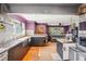 Bright kitchen and living room featuring stainless steel appliances, mosaic backsplash, wood floors, and sofa at 801 Hanover St, Aurora, CO 80010