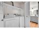 A clean and organized laundry area equipped with a washer and dryer and a shelf for storage at 201 Wright St # 105, Lakewood, CO 80228